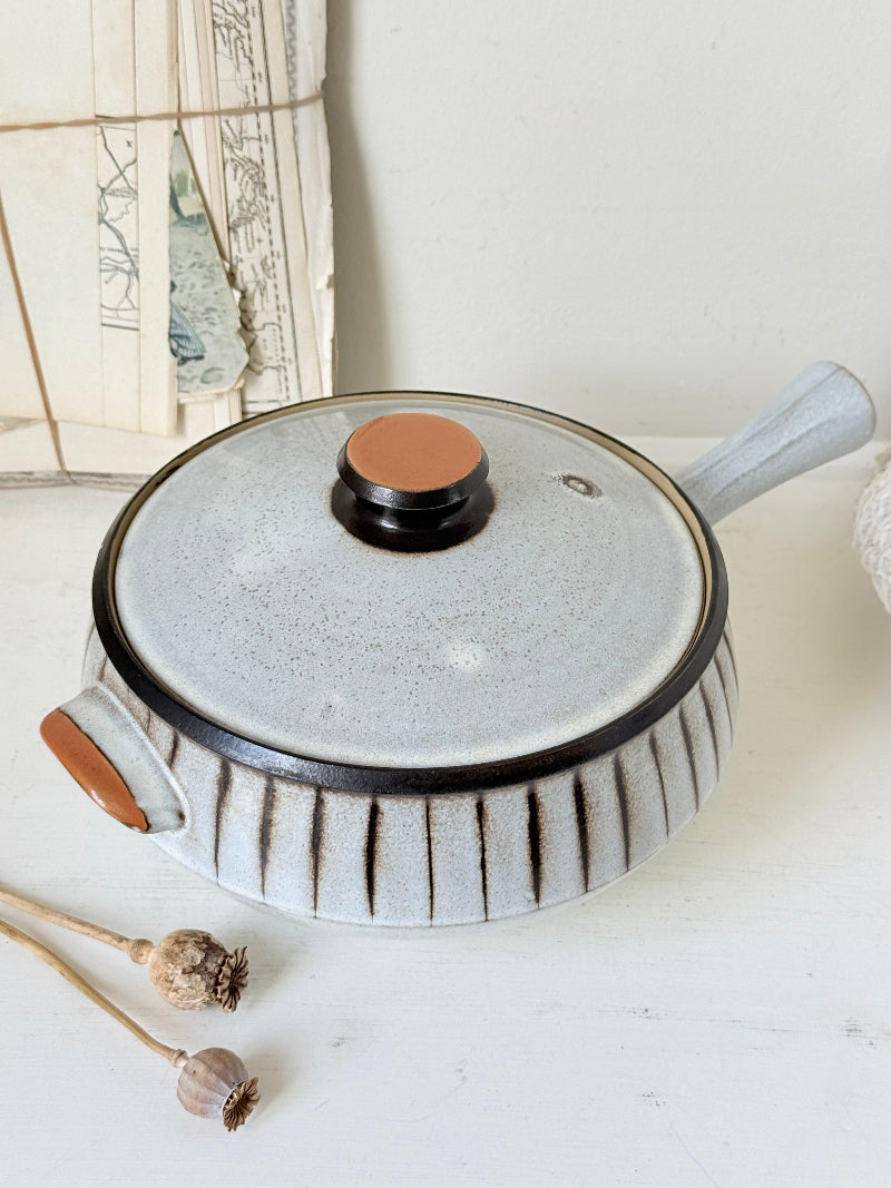 Denby Studio large two handled lidded casserole in grey and rust photographed on a white surface