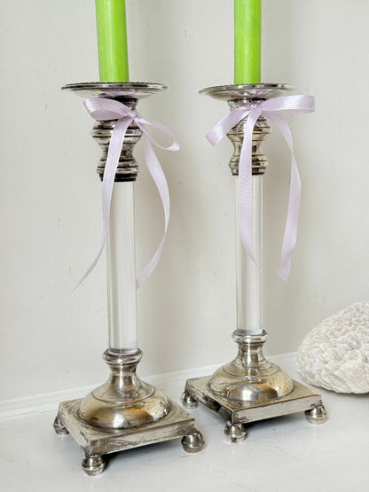 Pair of Hollywood Regency silver plate and Perspex Lucite candlesticks on bun feet with green taper candles