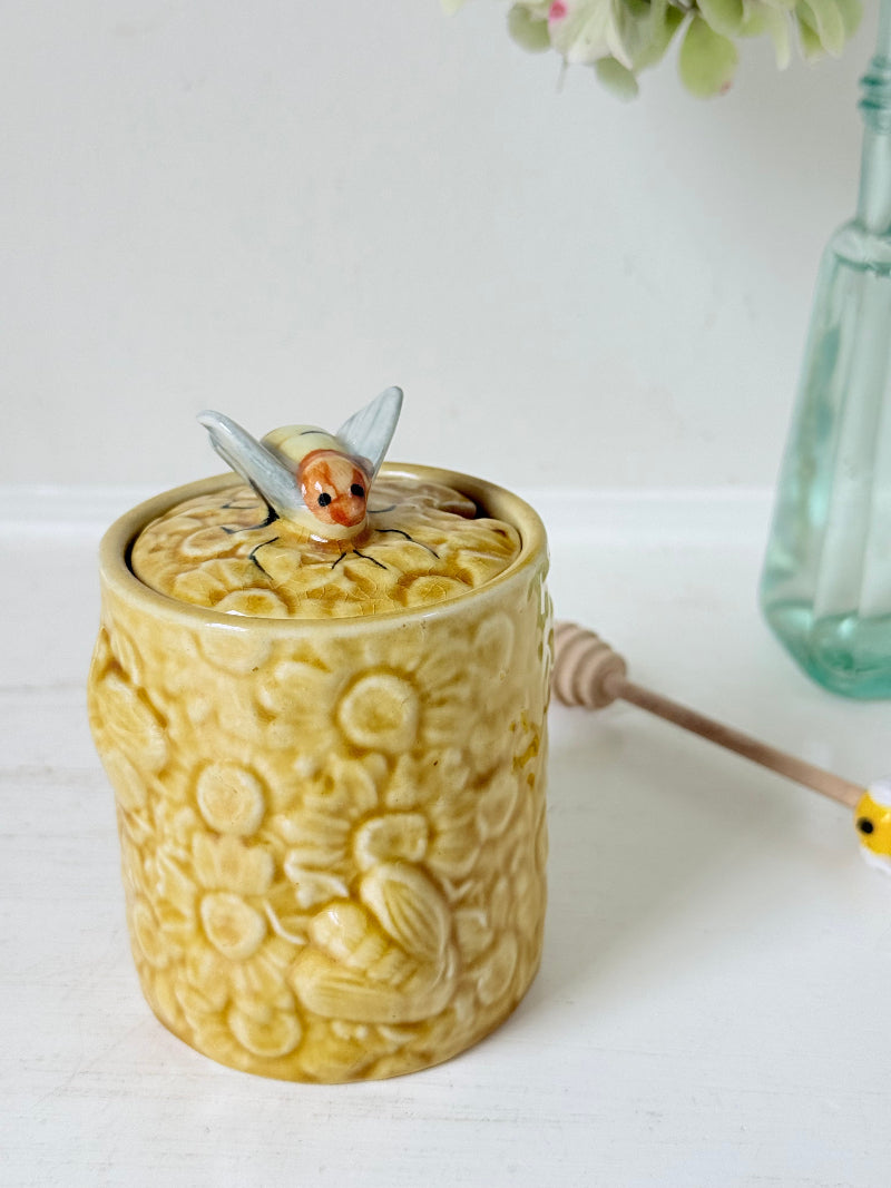 Secla pottery honey jar with lid, bee motif, and wooden honey spoon, made in Portugal, photographed on a white surface