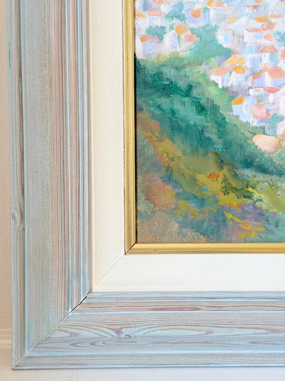 Framed oil painting of Costa del Sol with whitewashed hillside towns, photographed on a white surface