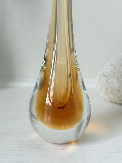 Amber and clear 1960s glass vase with narrow neck and rounded base, photographed on a white surface with dried stems.