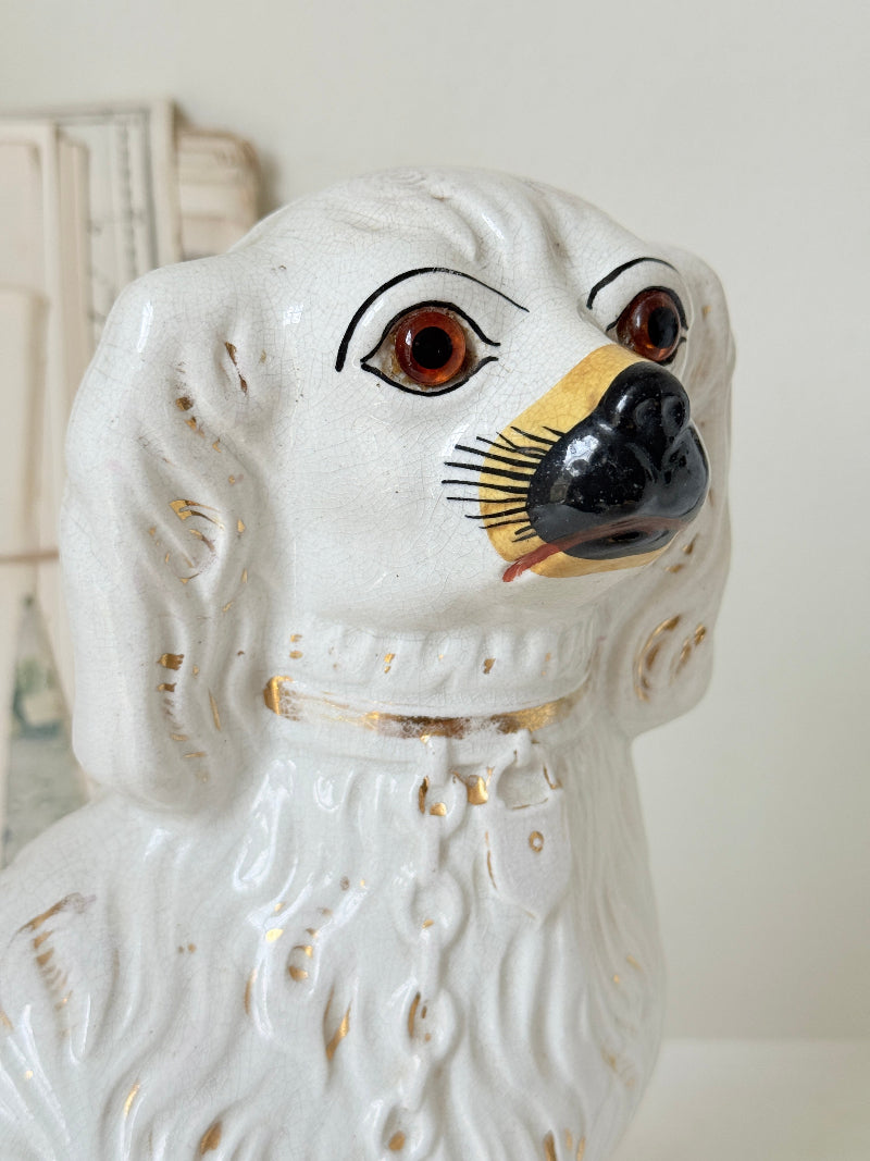 Near pair of antique white Staffordshire spaniel mantel dogs with glass eyes and worn gilt collars