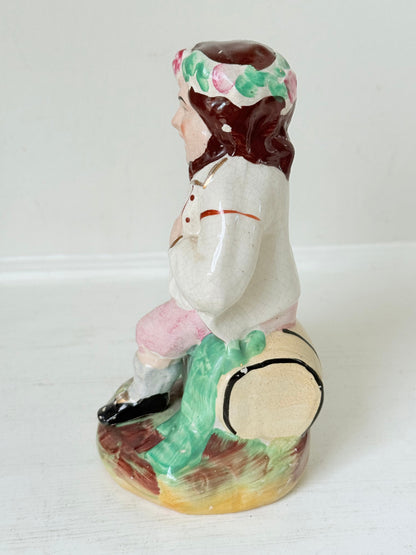 Bacchus antique Staffordshire pottery figure with painted details, photographed on a white surface.