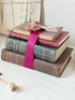 Vintage decorative book bundle with pink ribbon, dried flower detail and aged hardback covers for shelf and table styling