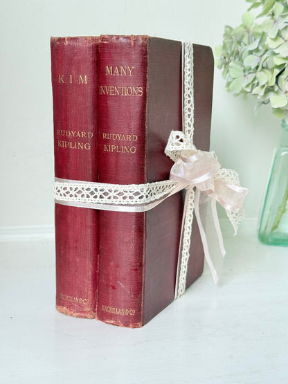 Pair of vintage Rudyard Kipling books in red cloth bindings with gilt lettering, styled as a decorative bundle, photographed on a white surface