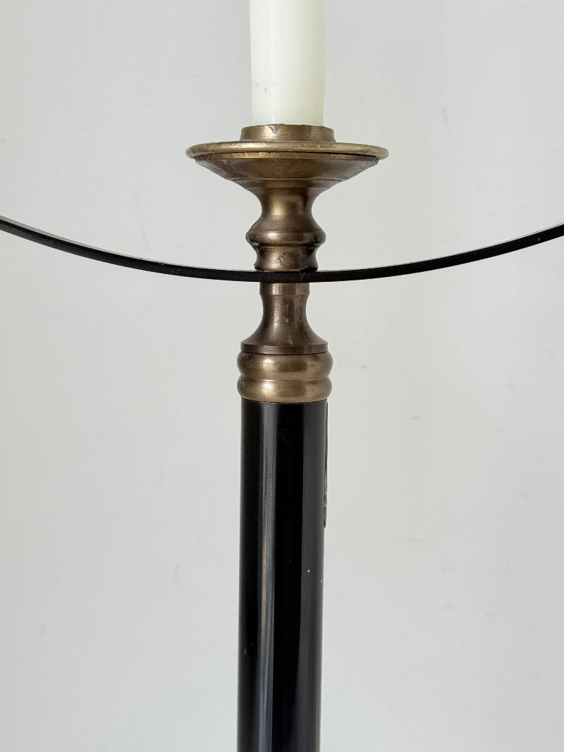 Vintage three arm candelabra in brass and ebonised metal with ivory taper candles styled on a white surface