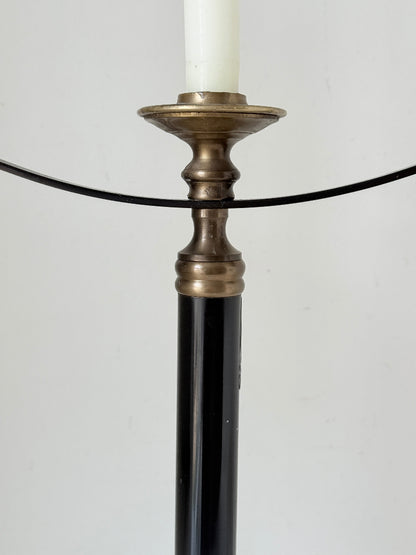 Vintage three arm candelabra in brass and ebonised metal with ivory taper candles styled on a white surface
