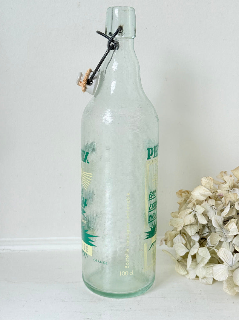vintage french soda bottle phenix aqua green glass with ceramic swing top 31cm on white surface