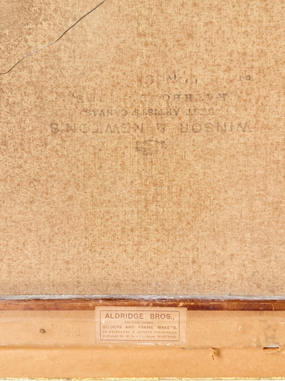 Close-up of the back of a framed artwork or print, showing tan textured paper, faint stamped text, and a wooden frame edge with a small label reading Aldridge Bros.