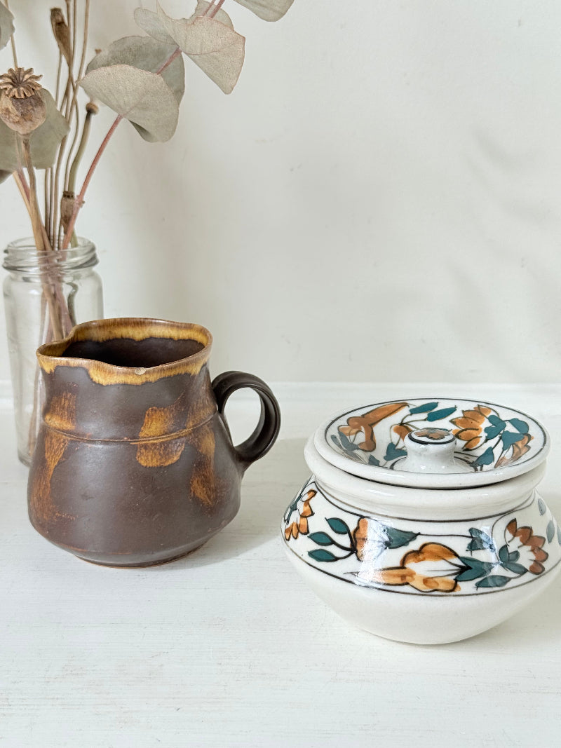 Studio pottery creamer and hand painted sugar bowl set, photographed on a white surface