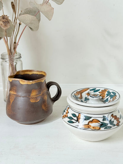 Studio pottery creamer and hand painted sugar bowl set, photographed on a white surface
