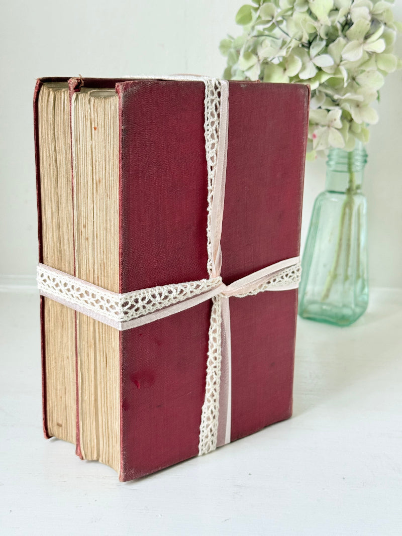 Pair of vintage Rudyard Kipling books in red cloth bindings with gilt lettering, styled as a decorative bundle, photographed on a white surface