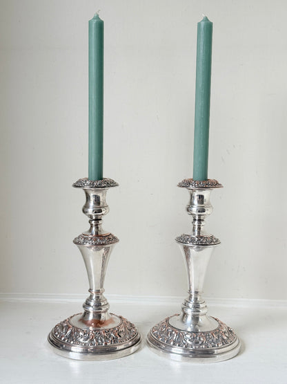 Pair of convertible silver plate on copper candelabra with repoussé detail, removable arms and green taper candles