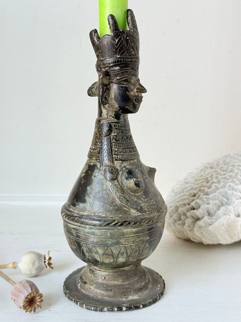 Antique Bengali anthropomorphic brass ritual vessel with goddess figure and lobed headdress, on a white surface