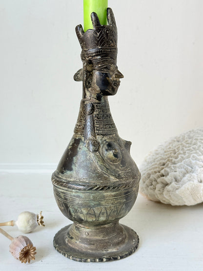Antique Bengali anthropomorphic brass ritual vessel with goddess figure and lobed headdress, on a white surface