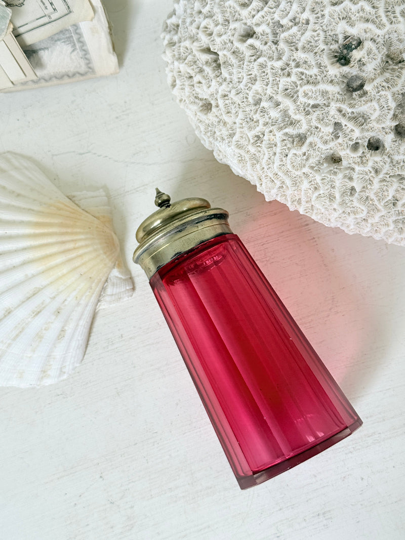 Antique cranberry glass sugar shaker with ribbed optic body, pierced metal top, star holes and deep pink glass