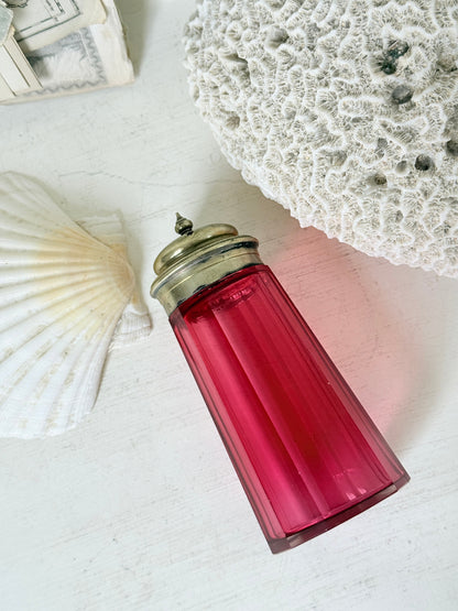 Antique cranberry glass sugar shaker with ribbed optic body, pierced metal top, star holes and deep pink glass