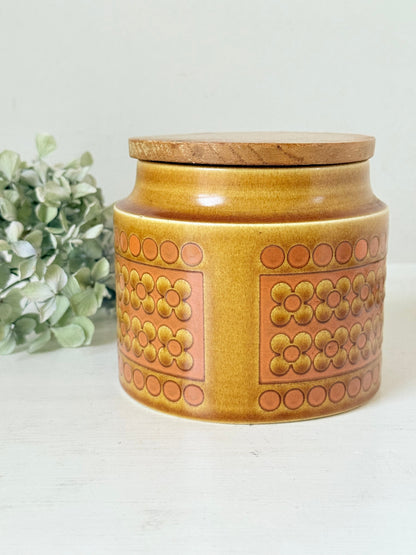 Vintage Hornsea kitchen canister in Saffron yellow with wooden lid photographed on a white surface.