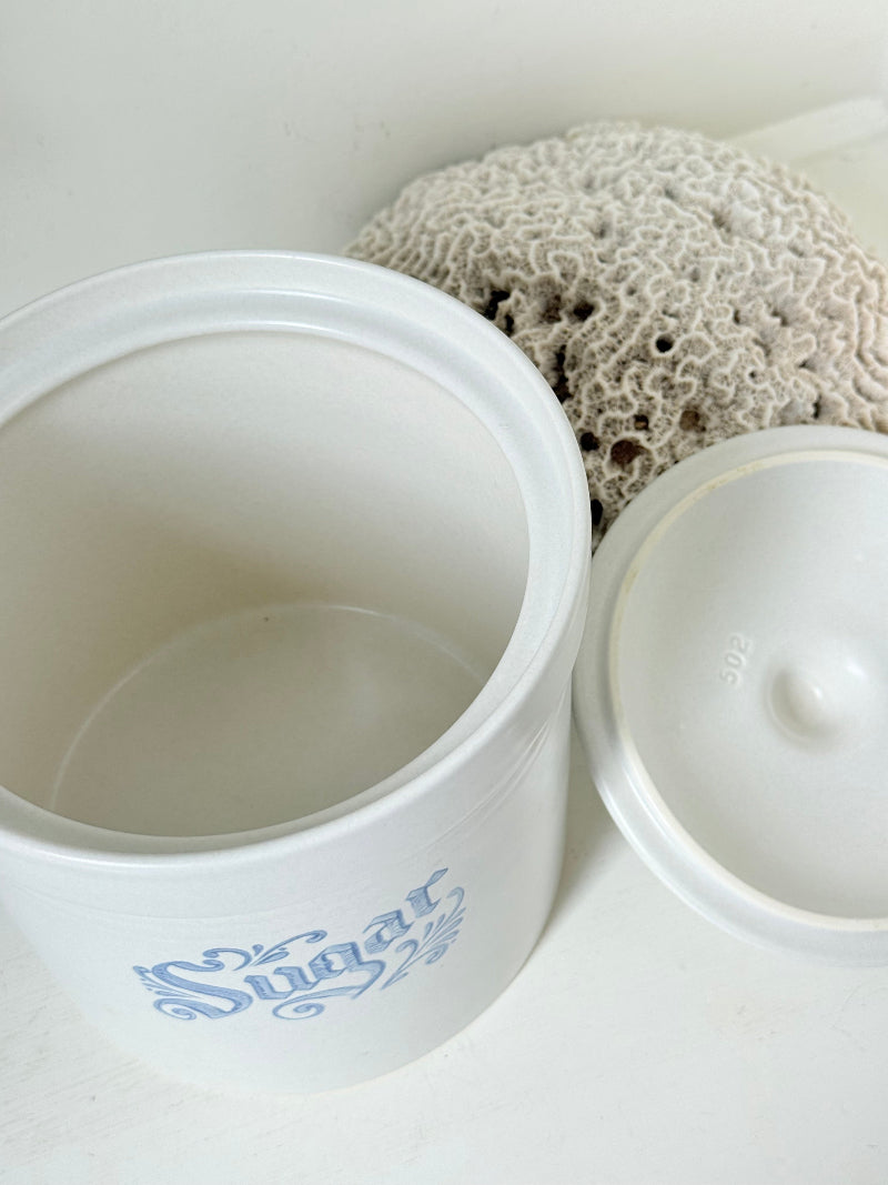 Pfaltzgraff Yorktowne stoneware sugar jar with blue floral motif and lid, photographed on a white surface