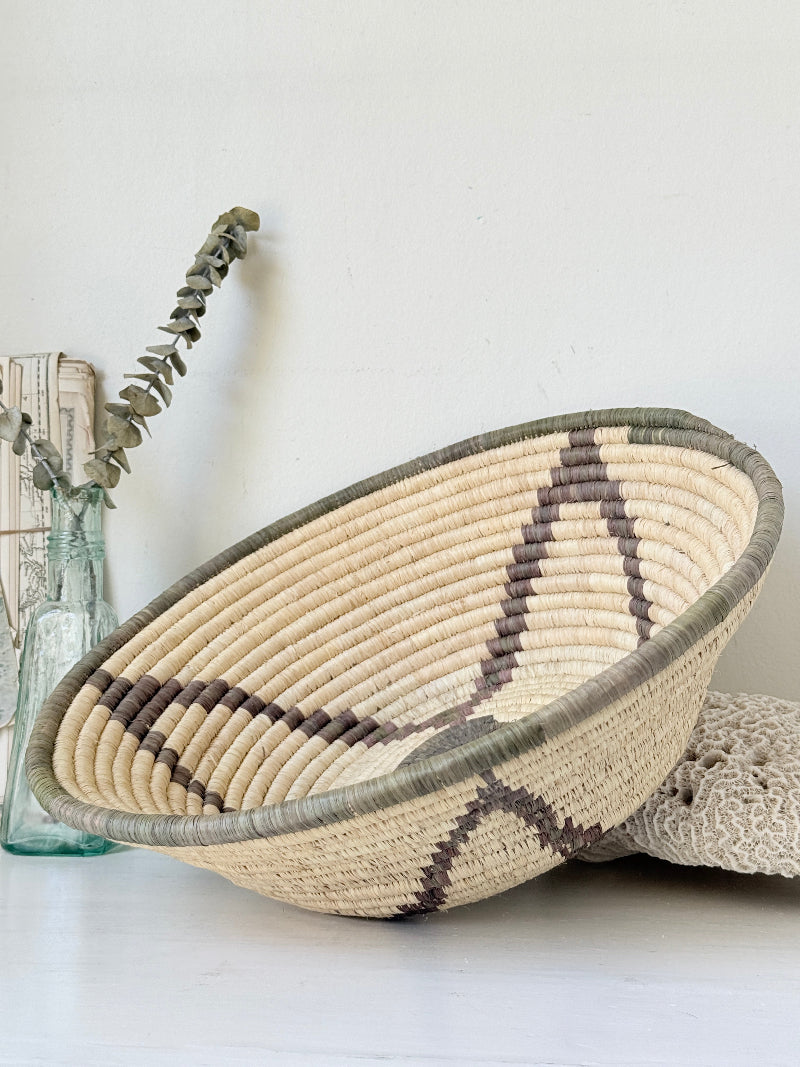 Large hand woven coiled basket with three point star pattern, natural fibre and dark geometric detail for wall or table styling