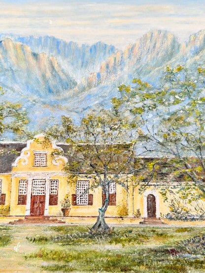 A watercolor landscape painting featuring a yellow colonial-style house with dark roofs, set in a grassy foreground with trees and blue mountains in the background under a pale sky.