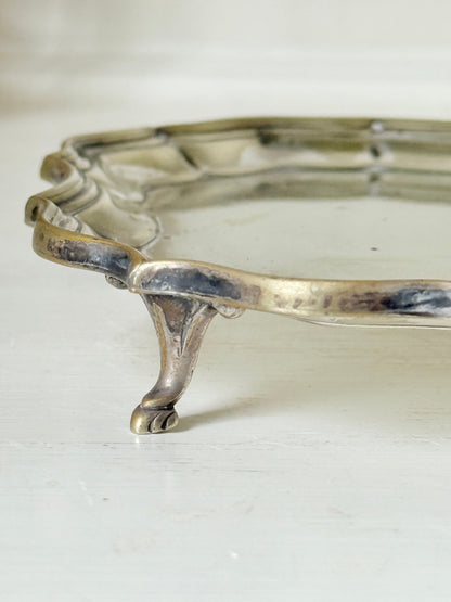 Vintage silver plate tray with scalloped edge and footed base, photographed on a white surface
