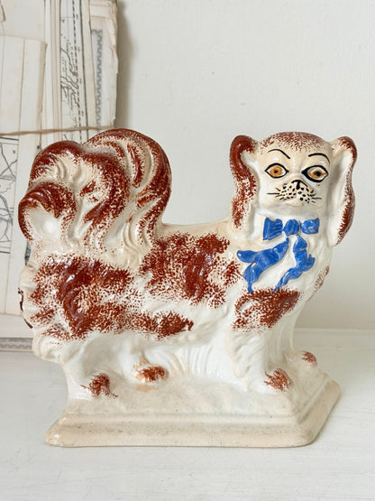 Pair of antique standing Staffordshire Pekingese dogs in rust red and white with blue painted bows