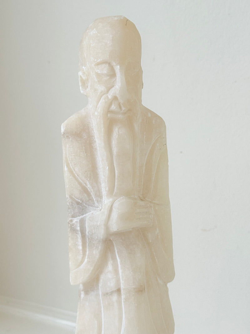 vintage alabaster gentleman figure on square base with carved detail, photographed on white surface with hydrangea flowers.