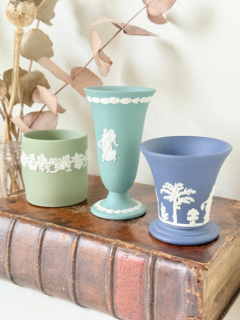 Trio of vintage Wedgwood Jasperware vases in green and blue with white relief decoration, photographed on a white surface