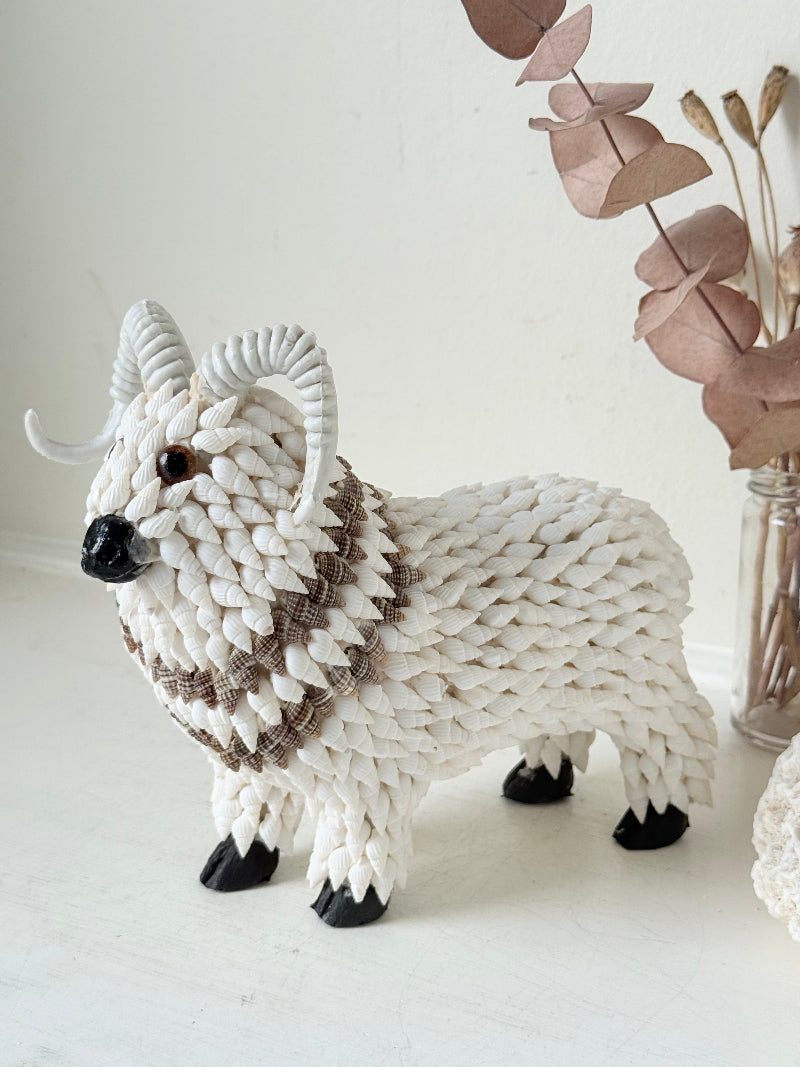 Vintage shell ram ornament in cream and brown, photographed on a white surface