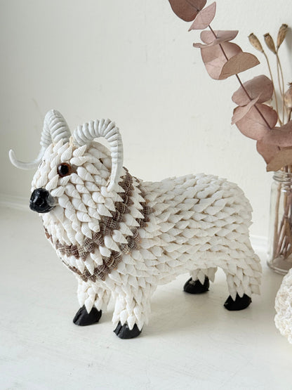 Vintage shell ram ornament in cream and brown, photographed on a white surface