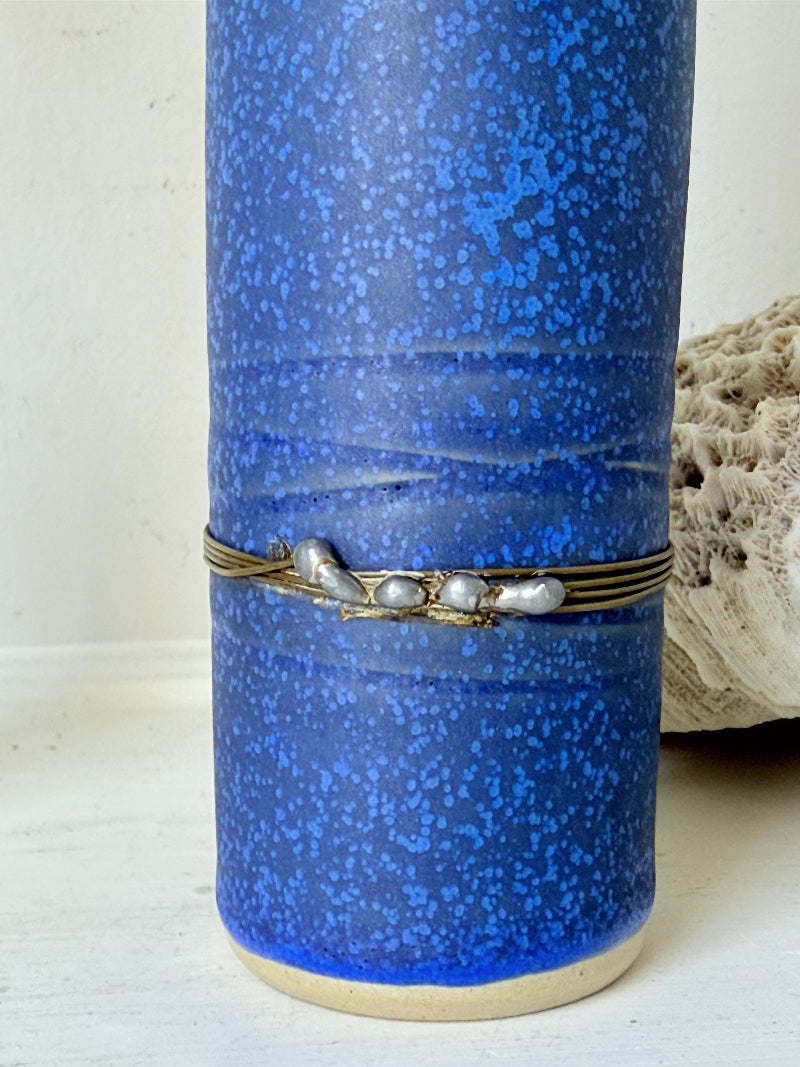 Tall vintage studio pottery bottle vase in turquoise and cobalt blue glaze, photographed on a white surface