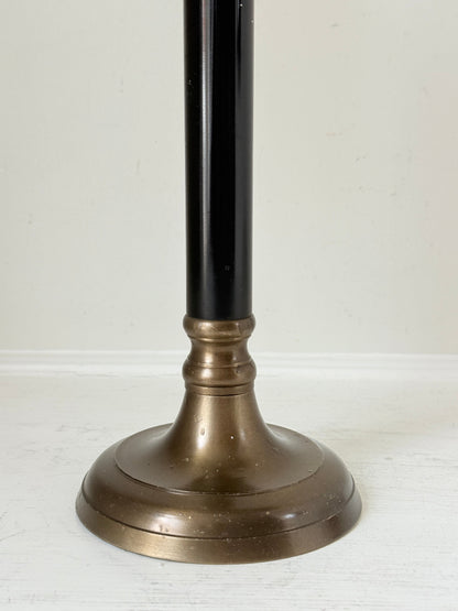 Vintage three arm candelabra in brass and ebonised metal with ivory taper candles styled on a white surface