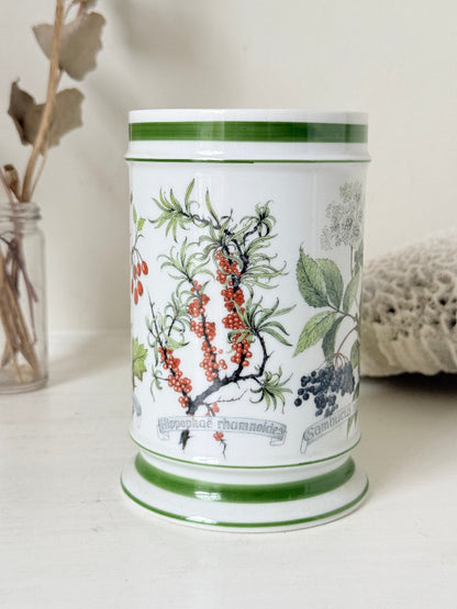 Vintage Kaiser W Germany porcelain utensil jar with botanical floral pattern and green rim photographed on a white surface