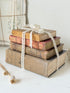 Antique decorative book bundle with faded hardback covers, aged pages and neutral lace tie for vintage interior styling