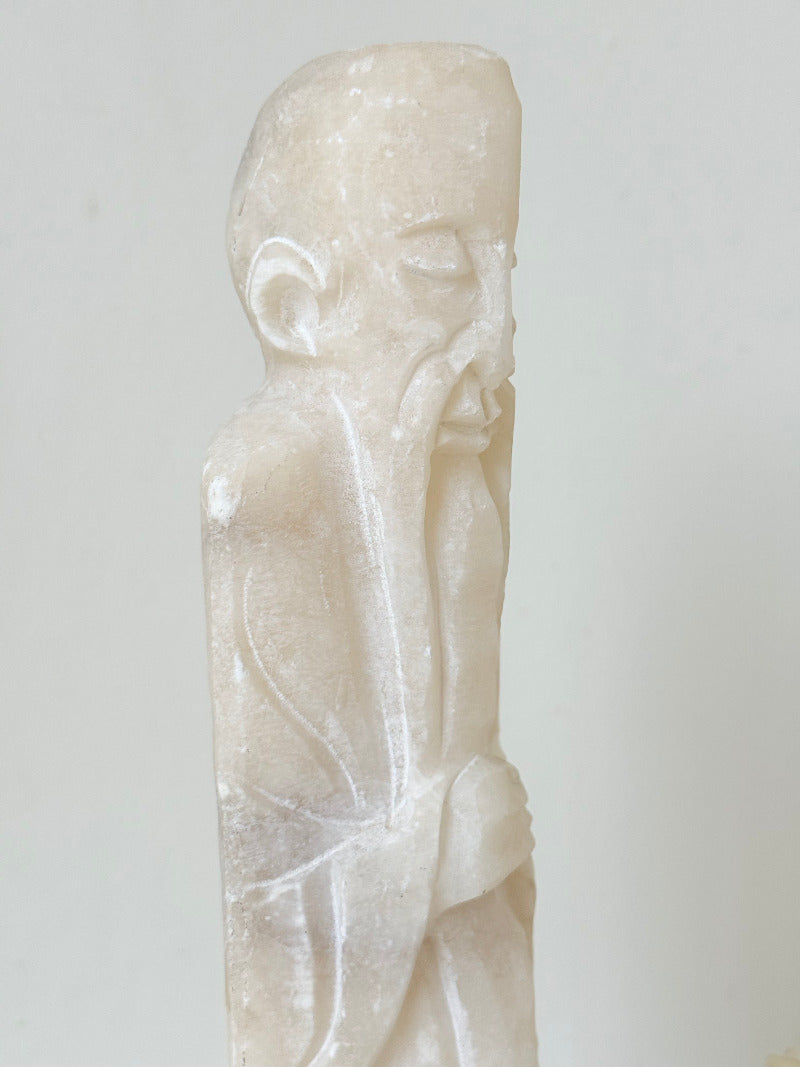 vintage alabaster gentleman figure on square base with carved detail, photographed on white surface with hydrangea flowers.