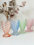 Set of 4 vintage pastel pressed glass mermaid goblets with textured scale pattern on a white surface