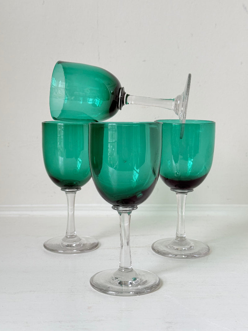 Antique set of four Bristol green liqueur glasses with clear stems, photographed on a white surface