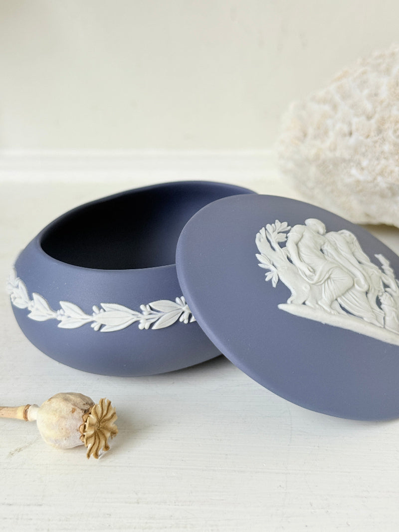 Vintage Wedgwood Jasperware Portland blue round lidded trinket box, decorated with a white neoclassical cameo and laurel wreath border.