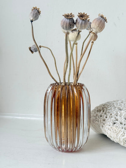 Vintage ribbed amber brown glass vase photographed on a white surface