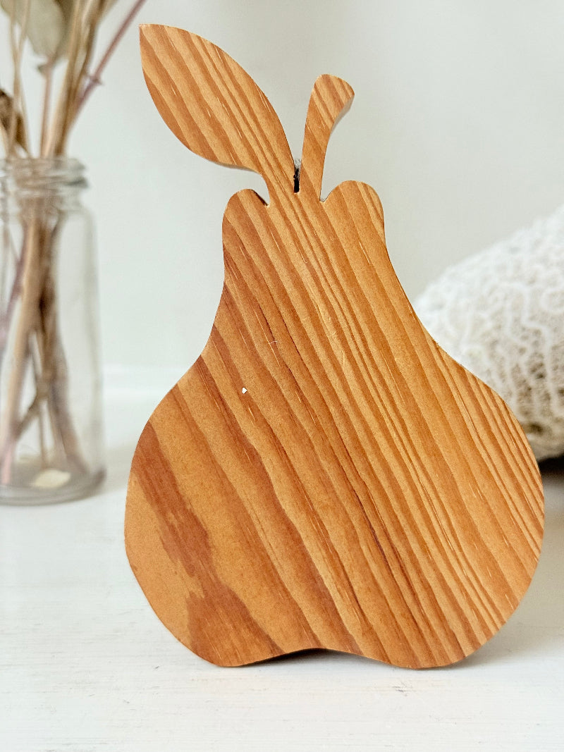 Vintage wooden pear sculpture in natural grain photographed on a white surface.