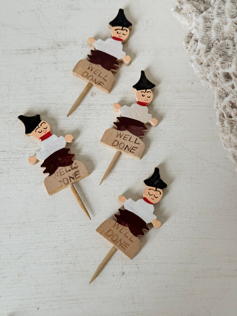 Vintage hand painted wooden steak markers on cocktail sticks labelled rare medium and well done, photographed on a white surface
