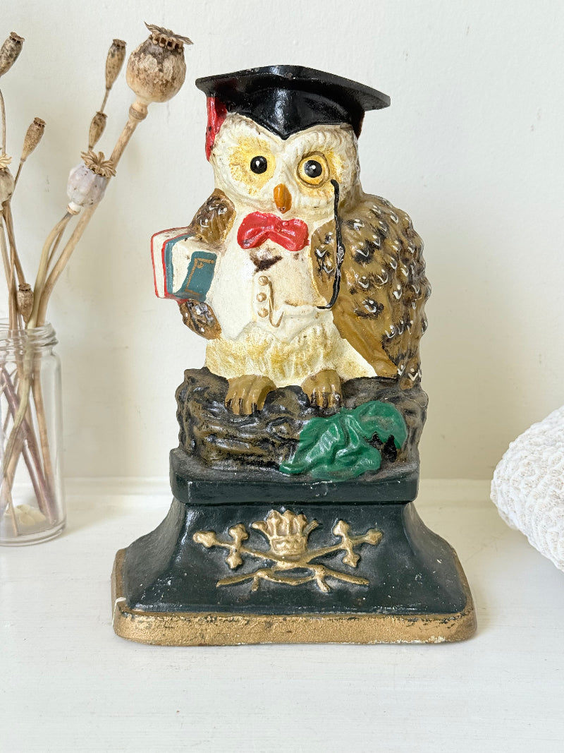 vintage hand painted cast iron owl doorstop with mortarboard and bow tie on white surface