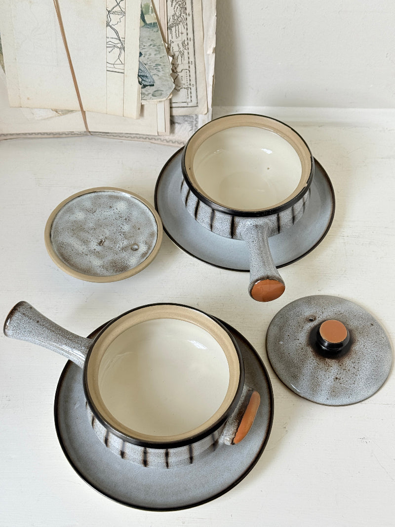 Denby Studio pair of lidded soup bowls with stands in grey and rust photographed on a white surface