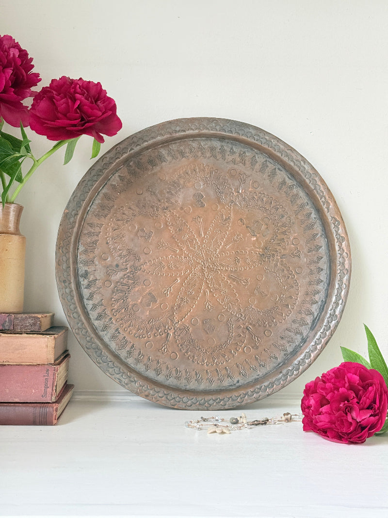 Vintage hand engraved copper tray with sunburst centre, decorative border and aged verdigris patina for wall or tabletop styling