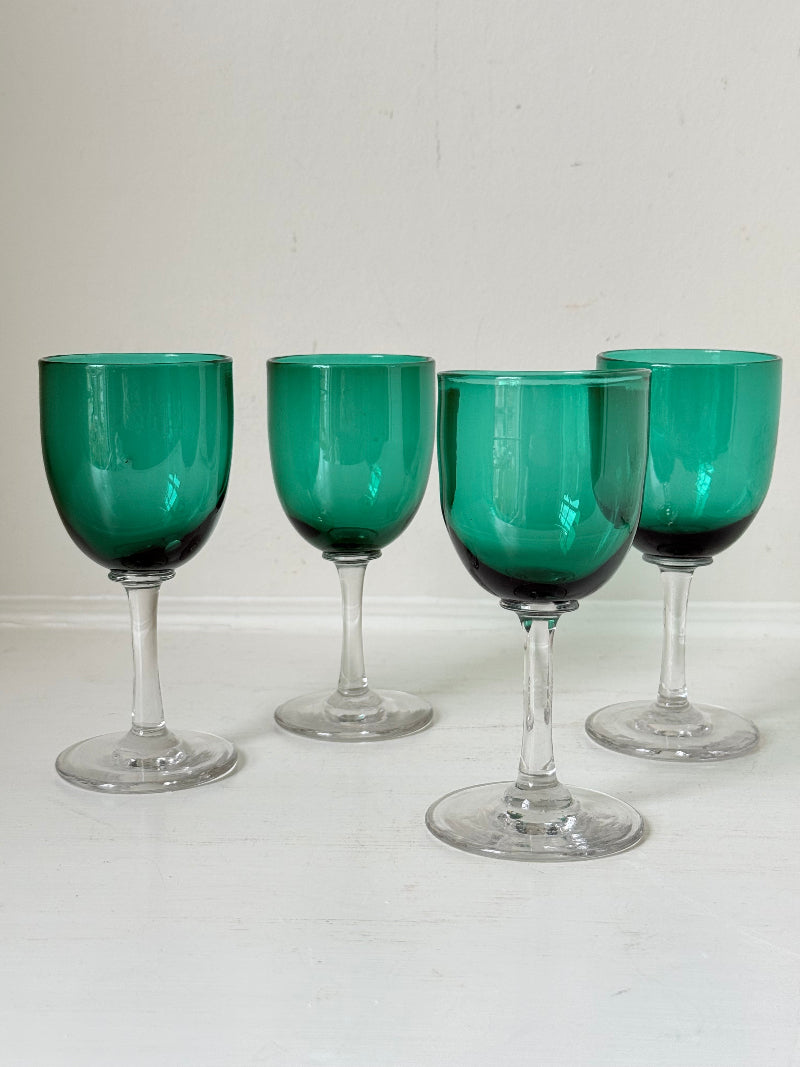 Antique set of four Bristol green liqueur glasses with clear stems, photographed on a white surface