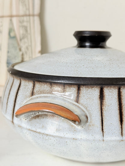 Denby Studio large two handled lidded casserole in grey and rust photographed on a white surface