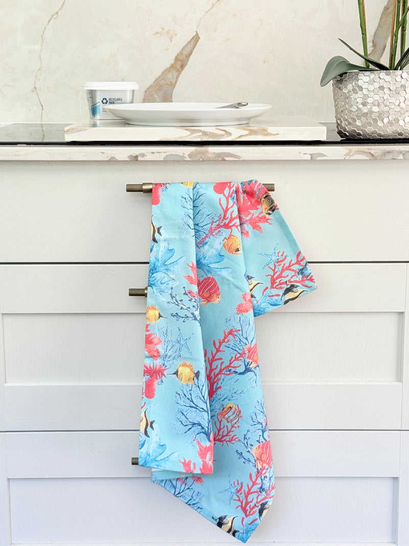 The Blue Loft Caribbean reef print cotton tea towel in turquoise with coral and tropical fish design