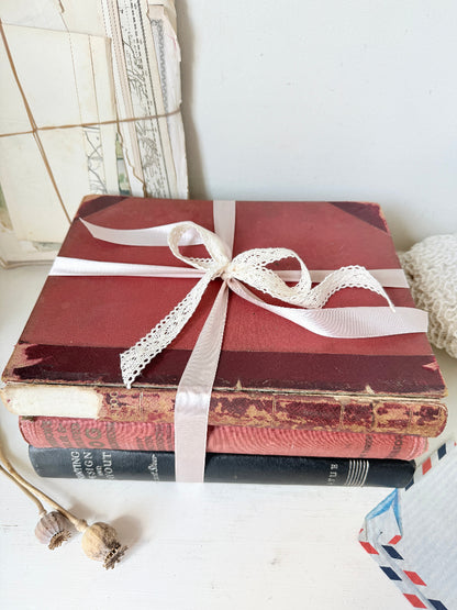 Large vintage decorative book bundle with burgundy cream and green hardback covers tied with ribbon for interior styling