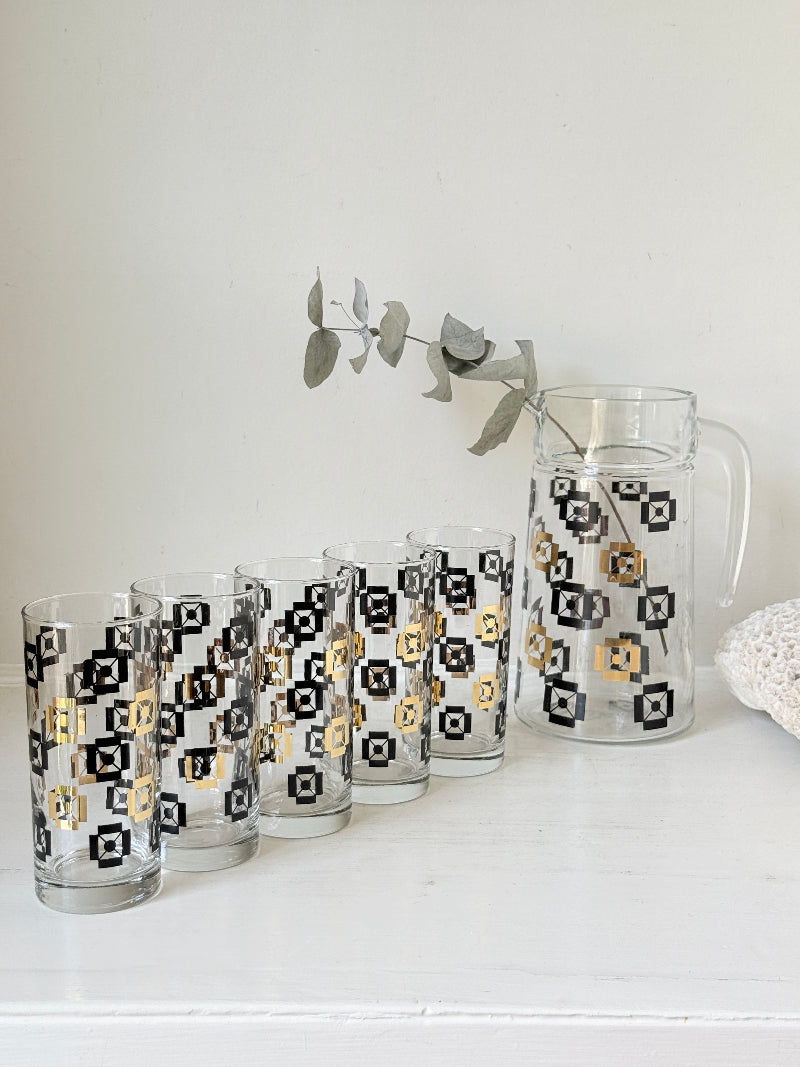 Mid century black and gold glass drinks set with jug and five highball tumblers in a geometric medallion pattern